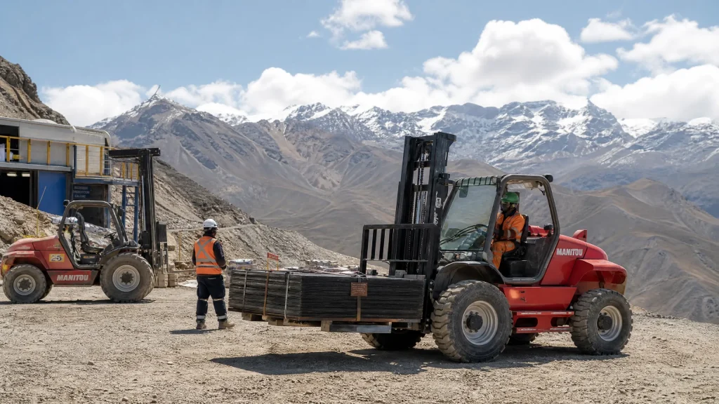 High-altitude mining operation in Peru's Andes mountains with diesel rough terrain forklift navigating rocky, steep terrain at extreme elevation with superior traction and stability